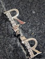 Close-up of letter "R" charm showing CZ stones and metal finish