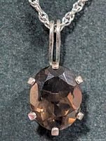 Close-up of smoky quartz pendant showing gemstone cut and prong setting
