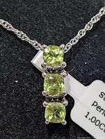 Close view pendant with three peridot stones and spinel accents