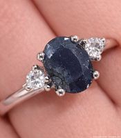 Ring on finger showing sapphire and CZ stones