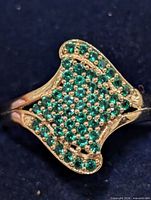 Top view of silver ring showing pave set green stones