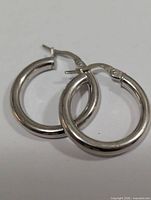 Front view of both silver hoop earrings showing design and finish