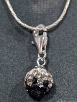 Close-up of pendant on silver chain showing pavé crystal detail