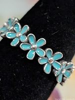 Front view showing turquoise enamel daisy design on silver band