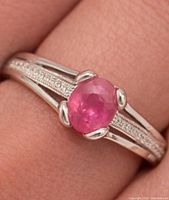 Ring on hand close-up showing center ruby and split shank design