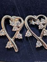 Front view of heart stud earrings showing CZ clusters