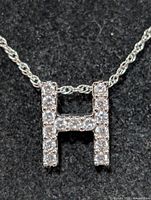 Close-up of CZ “H” pendant on chain