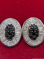 front view of both oval CZ earrings on red background