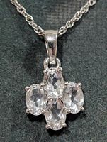Close-up of pendant showing four oval white topaz stones in silver prong setting