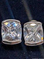 Front view of both earrings showing cushion-cut white topaz stones in silver bezels