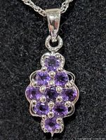 close-up of pendant showing nine amethyst stones and silver setting