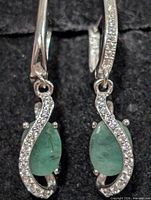 Front view showing emerald cabochons and CZ accents