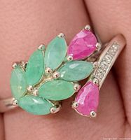 Top view of silver ring with emerald and ruby cluster