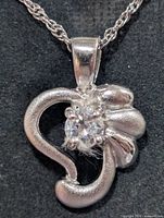 Close-up of pendant front showing cubic zirconia setting and metal finish