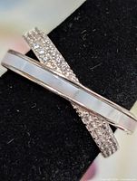 Front view of silver crossover ring showing mother-of-pearl inlay and pavé CZ