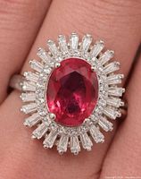 Front view of ring on finger shows created ruby and CZ halo