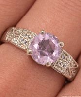 Ring on finger showing amethyst, silver band, accent stones