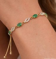Bracelet worn on wrist showing emeralds and CZ leaves