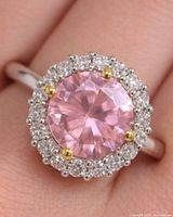 Top view of ring showing pink center CZ, clear halo stones, and yellow-tone prongs