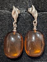 Front view of both earrings showing silver leaf post and amber cabochons