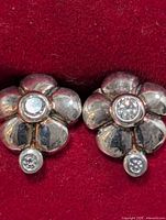 front view of both silver flower stud earrings showing cubic zirconia stones