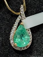 Front view pear-shape emerald with topaz halo
