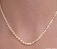 Pearl necklace worn on neck showing length and luster