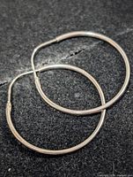 Front view of both hoop earrings on dark background