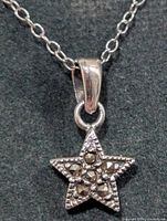 Close view of star pendant showing stone details and bail