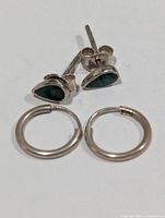 Both earring pairs laid flat showing fronts and clasps