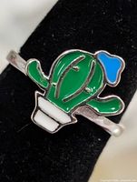 Front close-up of enamel cactus ring on display stand