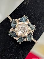 Top view of silver ring showing clear center stone and surrounding blue marquise stones