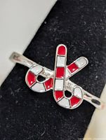 Front angled view showing red and white enamel candy cane motif on silver-tone ring