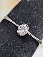 Front view of silver solitaire ring displaying round clear gemstone and setting