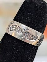 Front view of sterling silver toe ring on display mandrel, showing bean motif