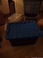 Large black Mastercraft tote with blue lid in front, other bins visible behind