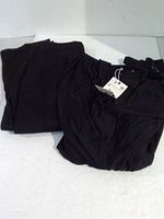 Niuru pants folded beside Zara dress with tag visible