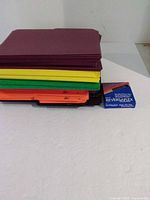 Stack of multi-colored file folders beside box of Oxford Reversaflex tabs
