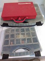 Three organizer cases stacked: red Thomas & Betts metal case on two clear plastic hardware organizers