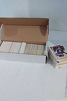 Open cardboard box showing rows of hockey cards next to loose stack