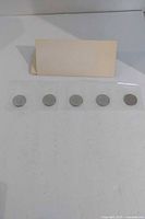 Five coins sealed in plastic strip