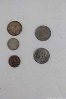 Front view of five coins arranged on white background