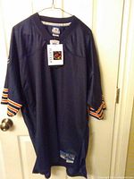 Full view of navy Chicago Bears Reebok jersey on hanger showing front, sleeves, tags