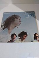 Front cover showing title "13" and band photo