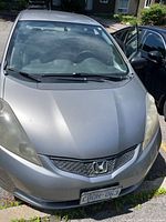Front view of silver 2009 Honda Fit showing hood, grille, headlights and Ontario plate