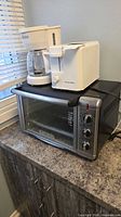 All three appliances stacked on counter: coffee maker, two-slice toaster, toaster oven
