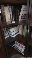 Rotating bookshelf section with assorted hardcovers and paperbacks stacked vertically and horizontally