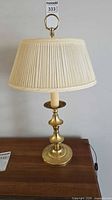Full view of brass table lamp with shade