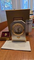 Clock front, presentation box, leaflet, pin box visible
