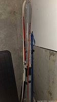 Skis and poles leaning against wall